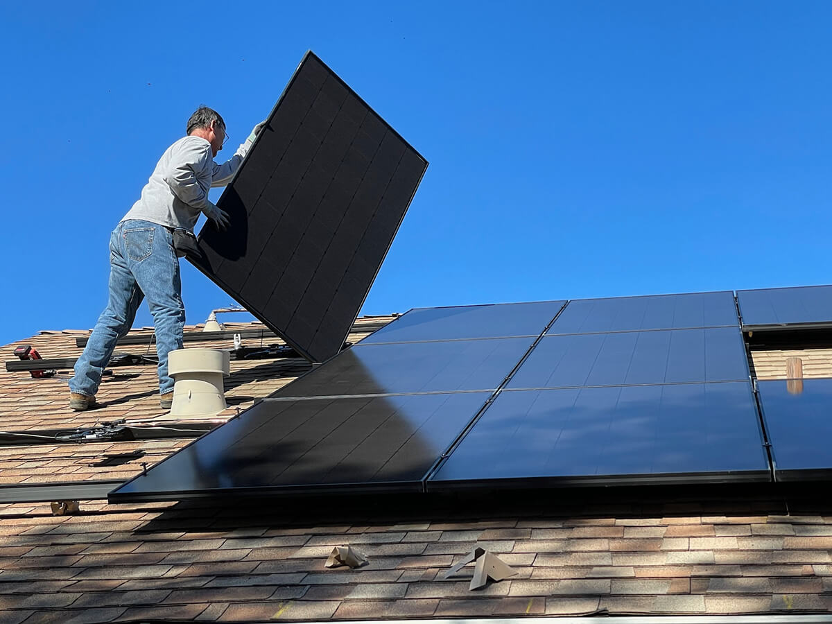 professionnel-installe-panneaux-solaires-toiture-maison-gants
